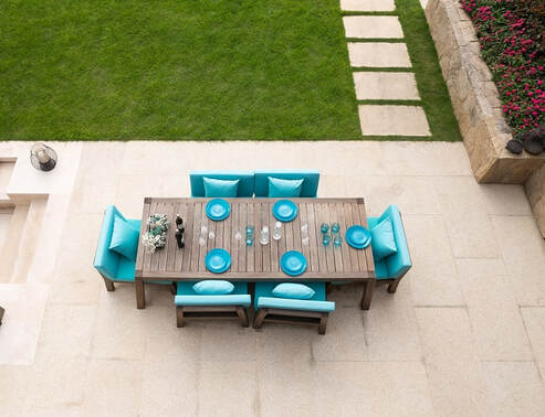 An wooden outdoor dining set on a concrete patio